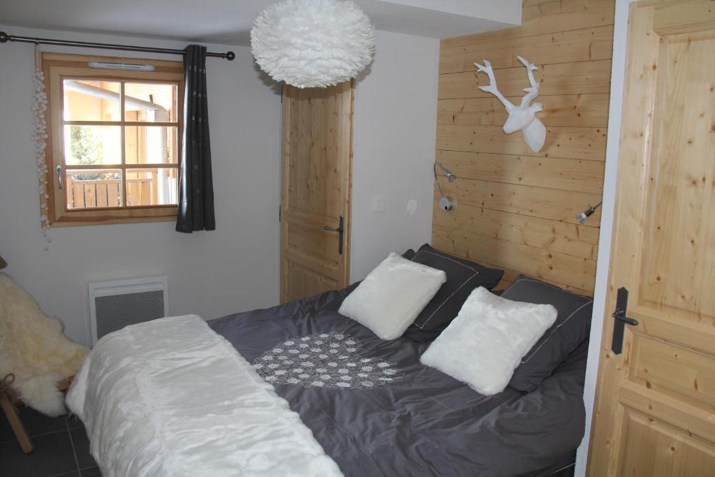 a bedroom with a bed with white pillows and a window at Résidence : Le Crystal Chalet in Les Deux Alpes