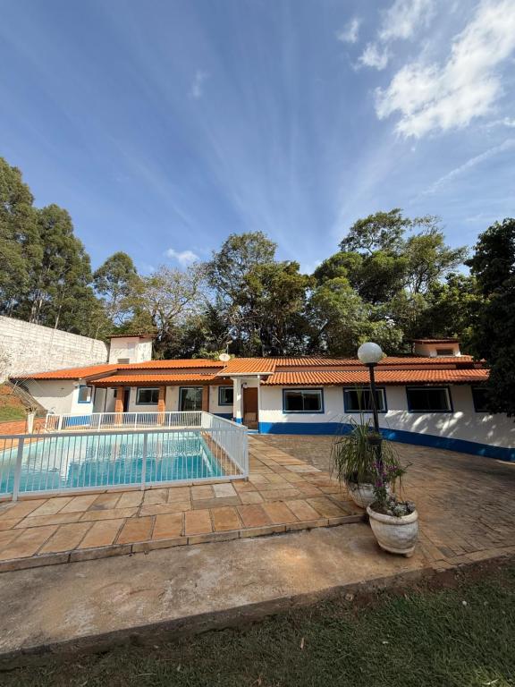 a house with a swimming pool in front of it at Chácara 3 quartos com piscina e churrasqueira in Itatiba