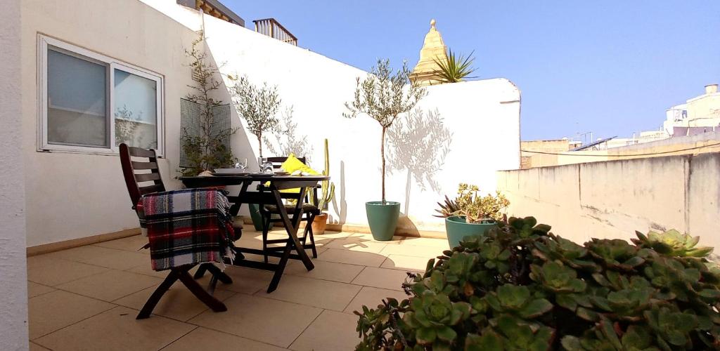 a patio with a table and chairs on a balcony at Ayla Studio House I Seaside Cosy and Modern in Birżebbuġa
