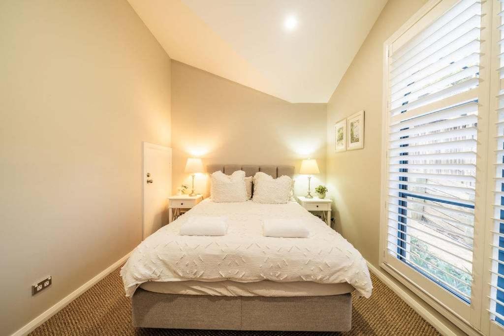 a bedroom with a large bed and a window at Avoca Beachside Retreat in Avoca Beach