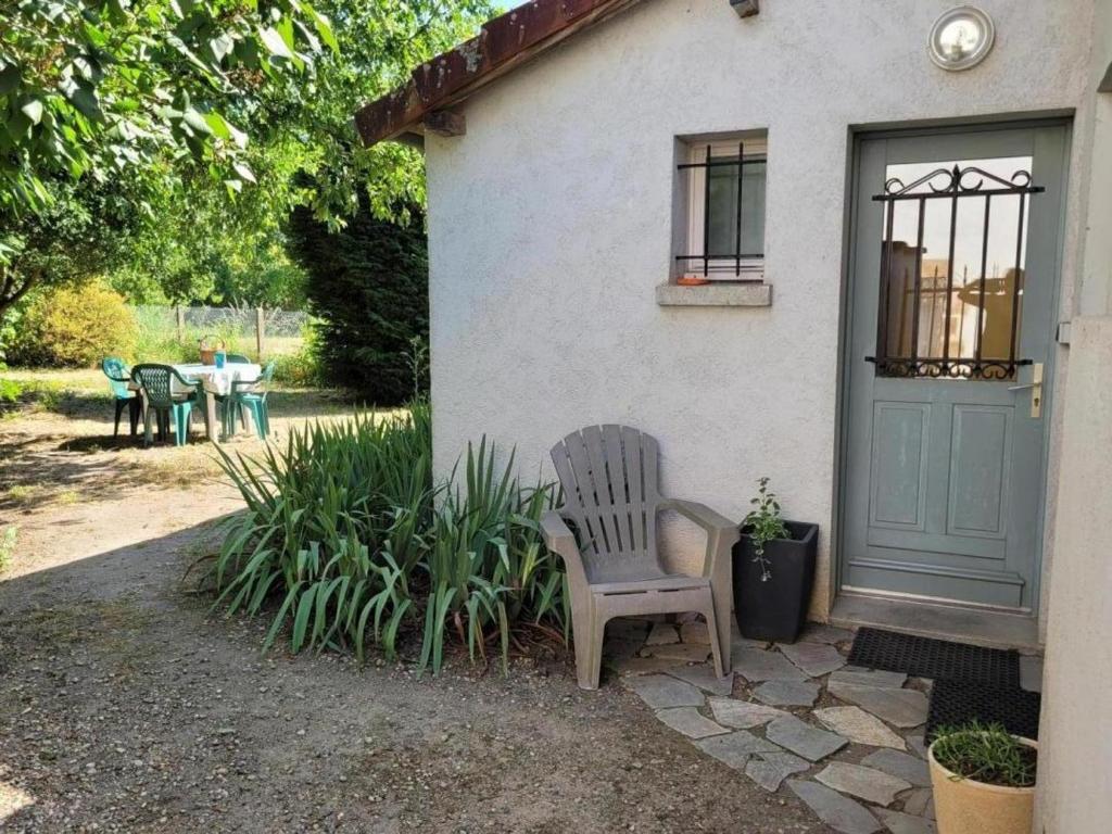 a chair sitting in front of a house with a table at Maison 2 chambres avec jardin clos en Sologne, animaux acceptés - FR-1-489-258 in Aurouer
