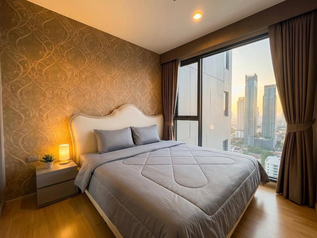 a bedroom with a large bed and a large window at BTS Thong Lor Central High -rise Condo in Bangkok