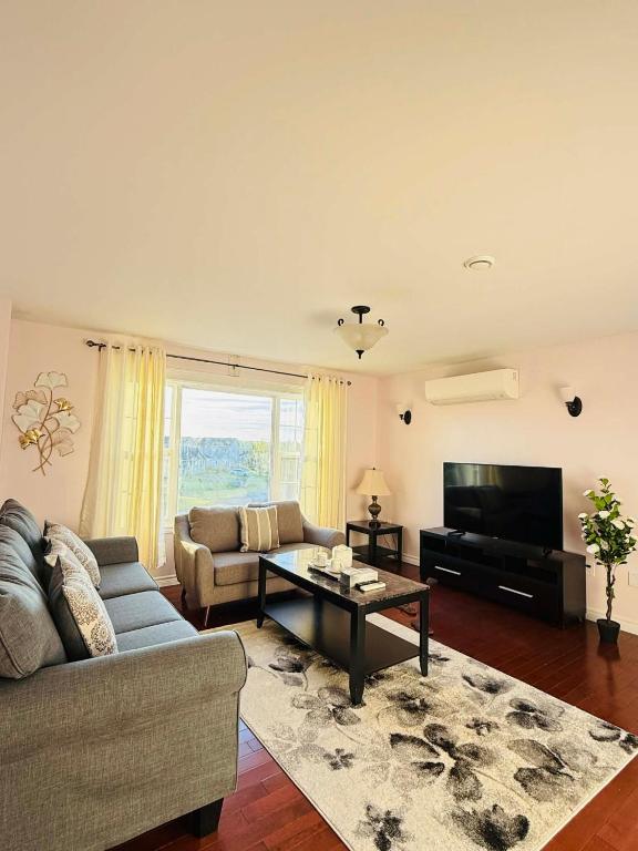 a living room with a couch and a tv at Private MasterBedroom in Charlottetown
