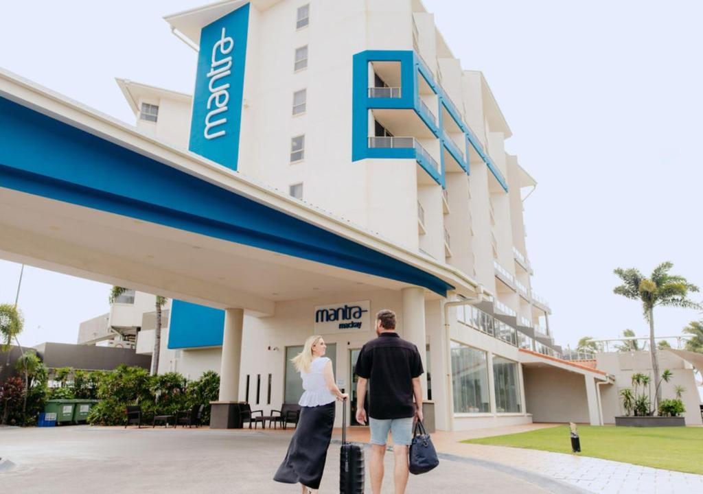 a man and a woman standing outside of a hotel at Mantra Mackay in Mackay