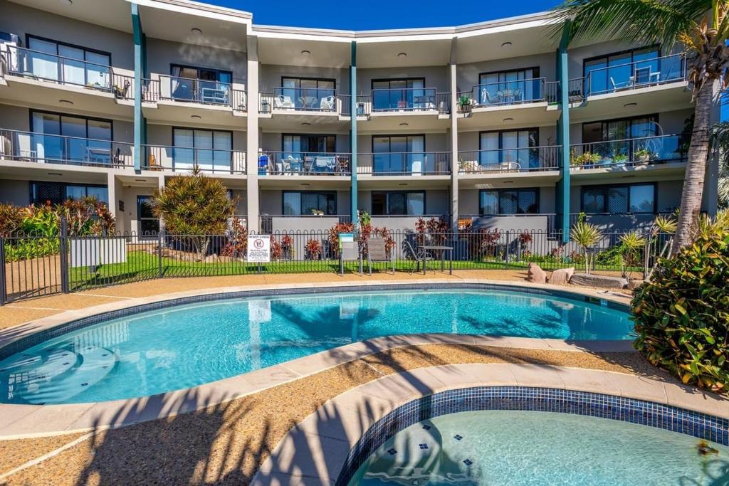 a swimming pool in front of a hotel at Sea Air 24 in Yeppoon