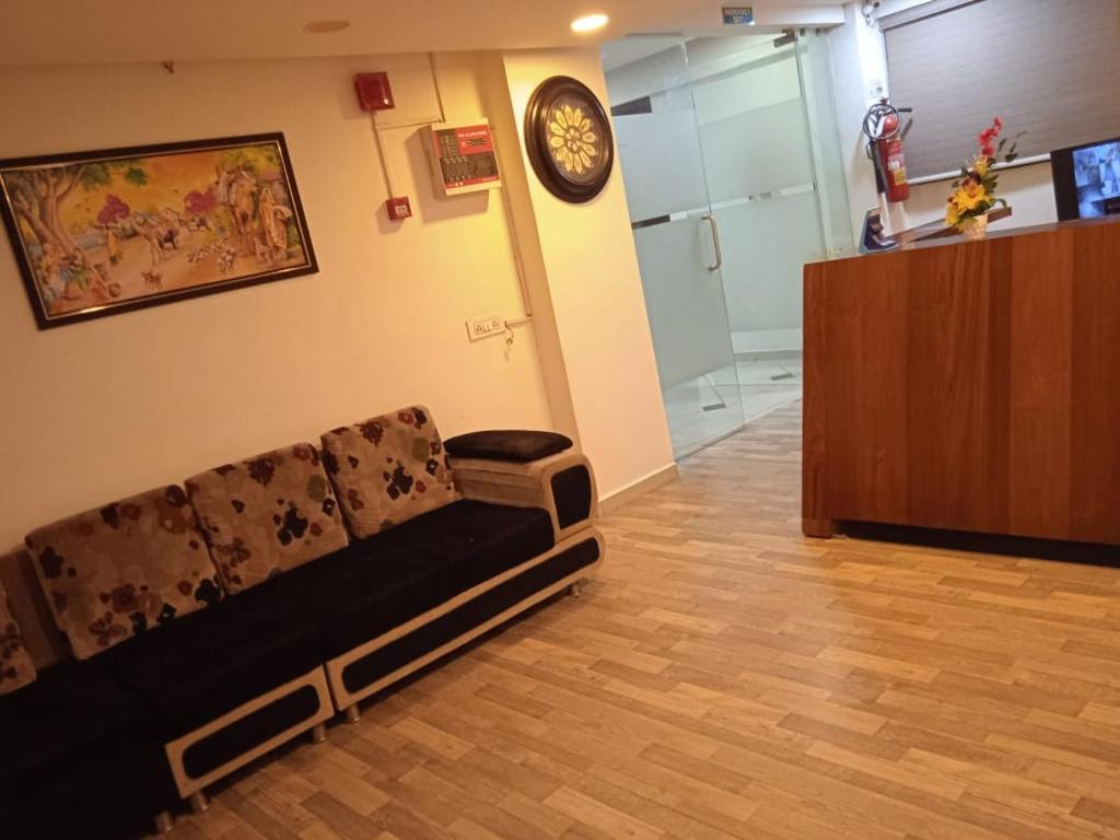 a living room with a couch and a clock on the wall at Hotel ShivInn in Gandhinagar