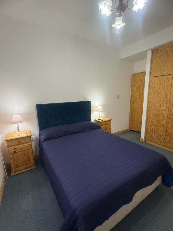a bedroom with a purple bed and two night stands at Acordes de Gaitas - Departamento 1 in Malargüe