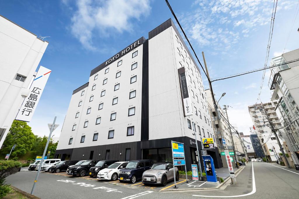 a building with cars parked in a parking lot at KOKO HOTEL Himeji Castle in Himeji