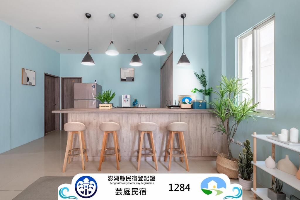 a kitchen with blue walls and a counter with stools at Penghu Yun Ting Style Inn in Magong