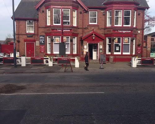 a man standing in front of a red brick building at The Navigation Inn Hotel in Derby