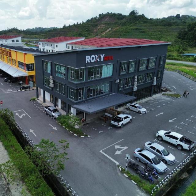 a building with cars parked in a parking lot at Roxy Hotel Selangau in Rumah Kudan