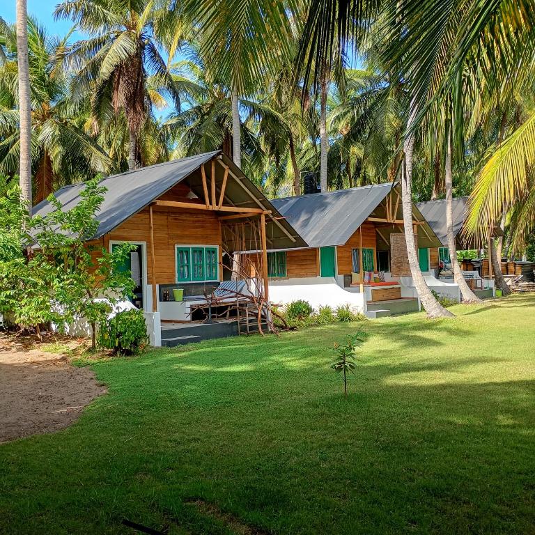 a house with a gambrel roof on top of a yard at Salt Bay Kite and Dive Resort in Kalpitiya