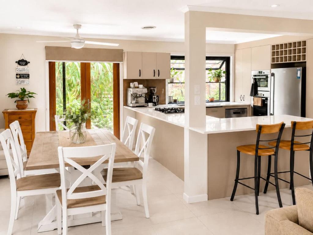 a kitchen and dining room with a table and chairs at William's on William - Stylish 2 Bedroom Haven in Ormiston