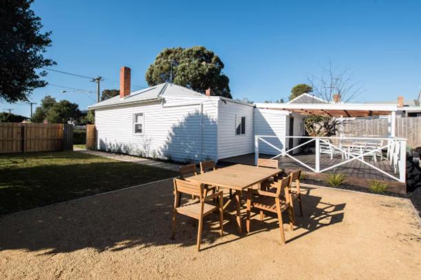 a table and chairs in front of a house at Coastal Cottage Retreat in Barwon Heads