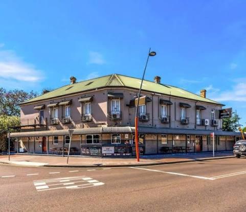 a large building on the corner of a street at Imperial Hotel Singleton in Singleton