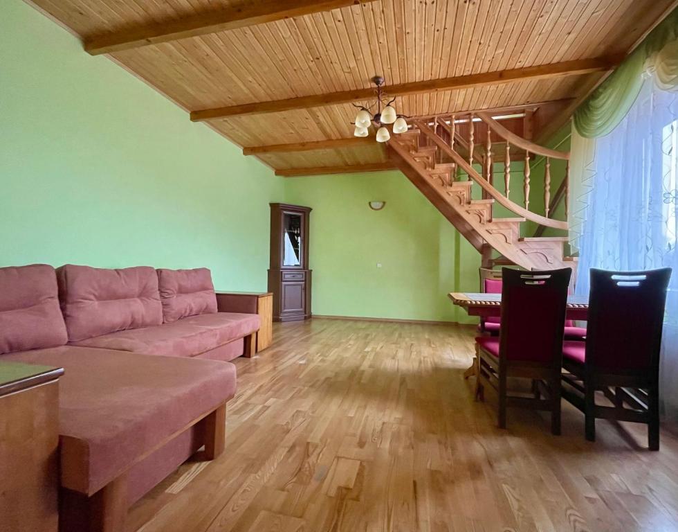 a living room with a couch and a staircase at Passage Apartments 10a in Skhidnitsa