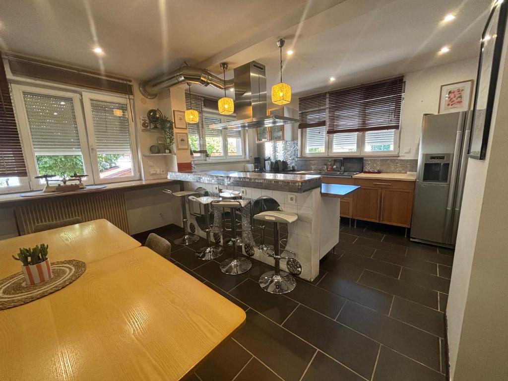 a large kitchen with a table and a counter at L'Escapade Sélestadienne in Sélestat