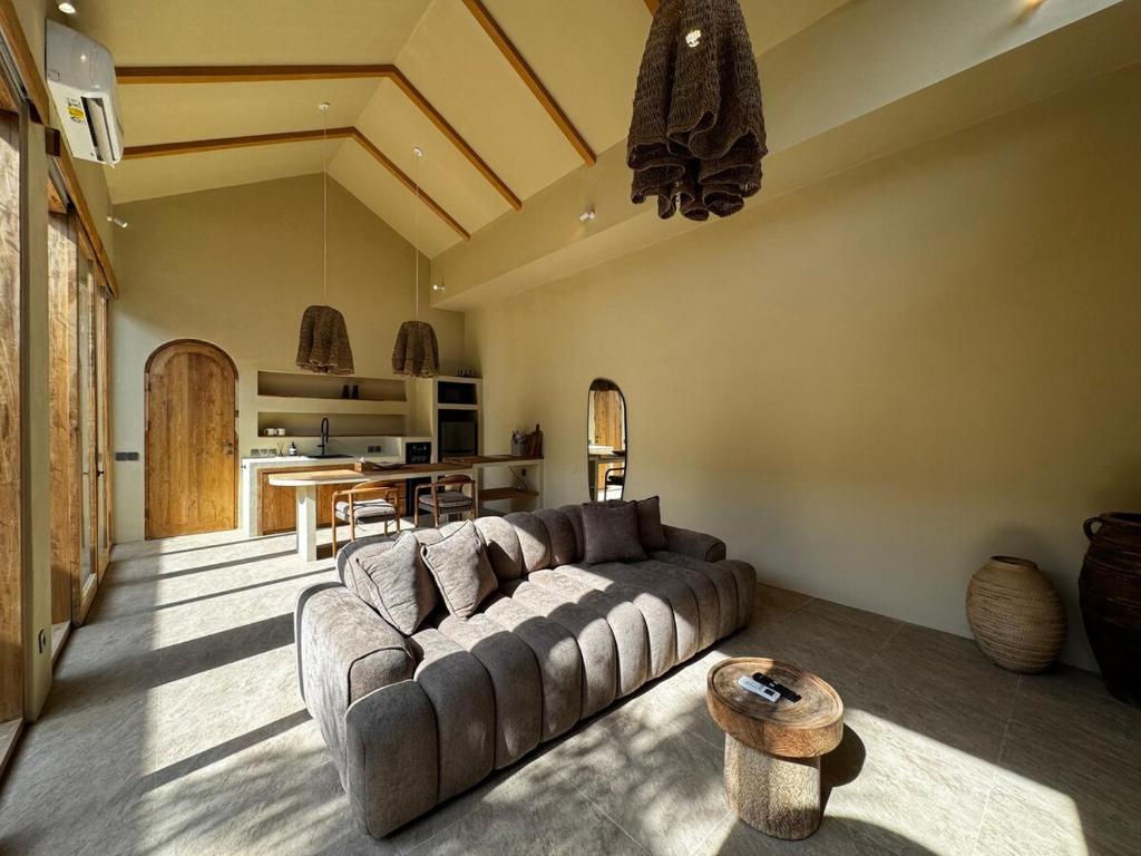 a living room with a couch and a table at 1 BR Private Pool Villa for Two - Casa Manja in Krambitan