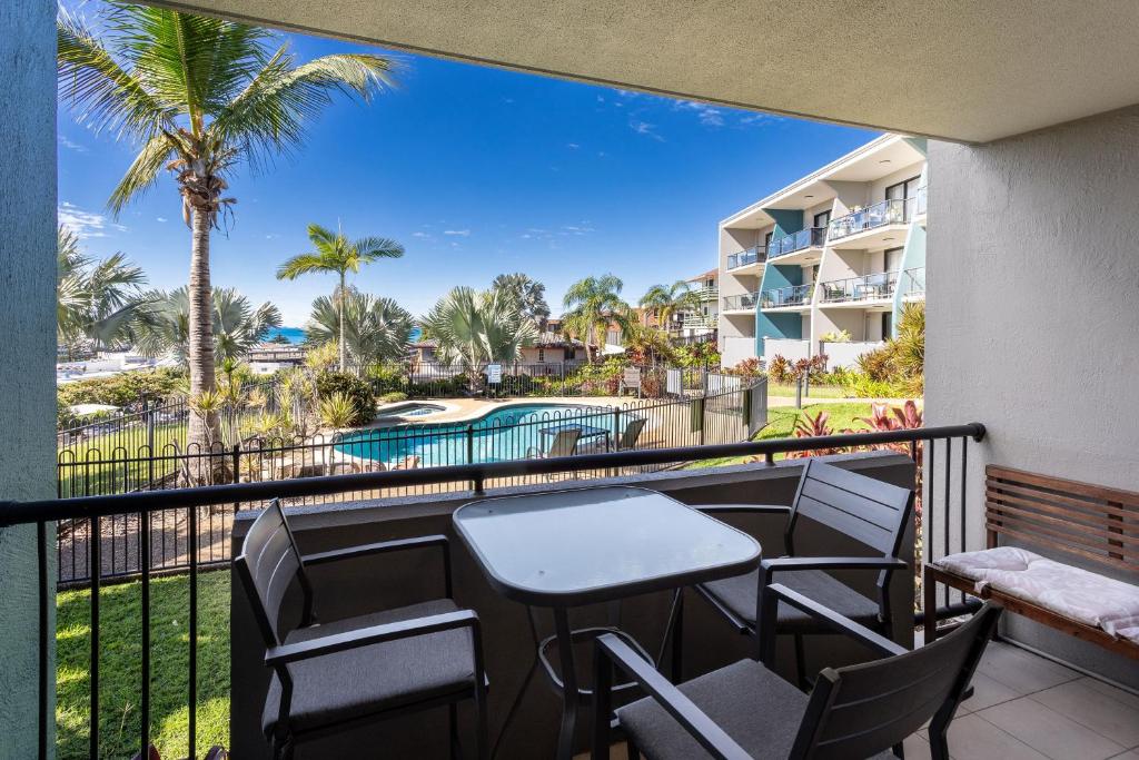 a balcony with tables and chairs and a view of a resort at Sea Air 2 in Yeppoon