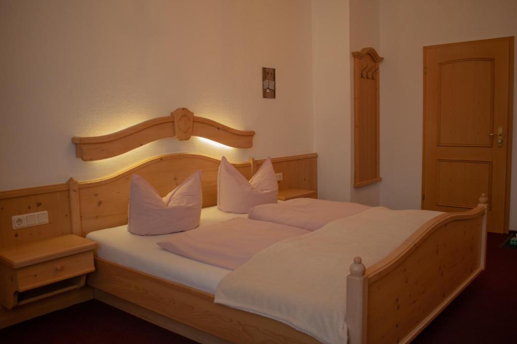 a bedroom with two beds with white pillows at Pension Haus Marga in Wernigerode