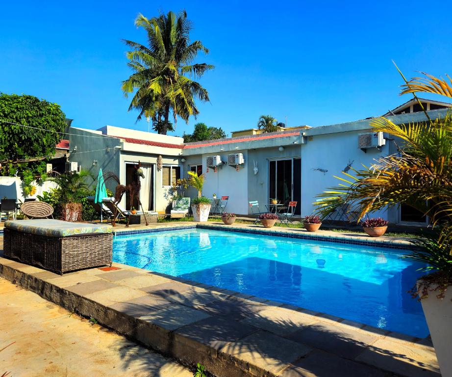 a swimming pool in front of a house at Guesthouse MALAGUETA INN II in Maputo