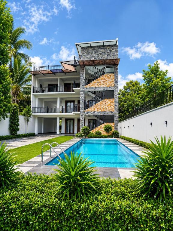 an exterior view of a building with a swimming pool at Villa 777 in Kadawata