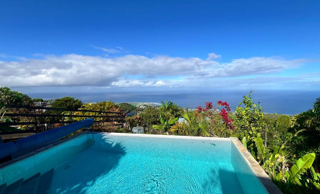 a swimming pool with a view of the ocean at Villa TheOceane in Les Avirons