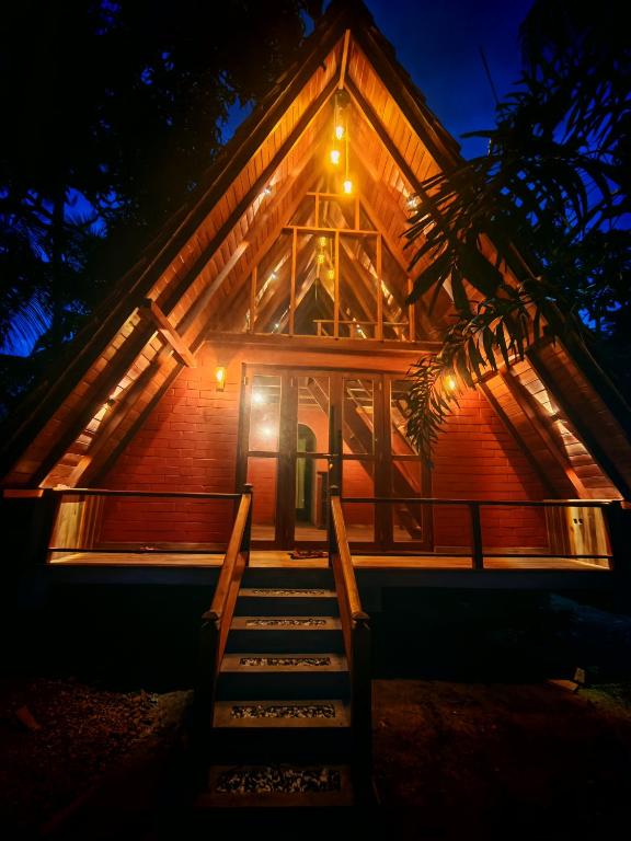 a house with stairs leading up to it at night at Paddy field Whispering wind Cabin in Ahangama Nakanda