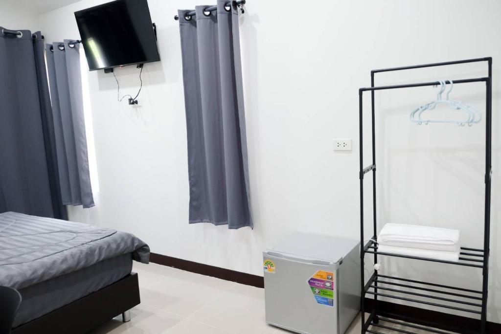 a bedroom with a bed and a tv in it at Safezone Resort Suanluang in Sathani Ban Hua Mak