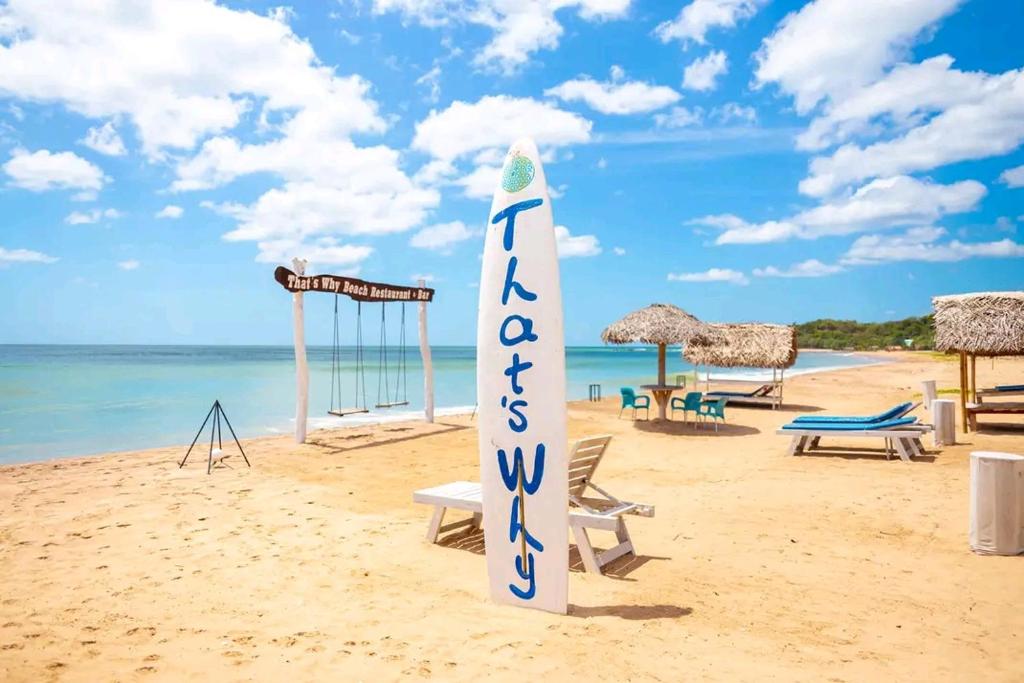 a surfboard on a beach with chairs and a playground at That's Why Nilaveli Beach Cabanas in Trincomalee