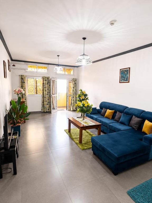 a living room with a blue couch and a table at KFC Homes in Yaoundé