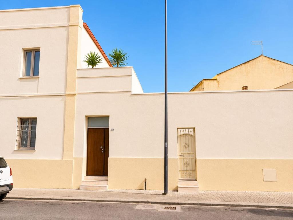 a white building with a door on a street at Marconi 306 in Quartu Sant'Elena