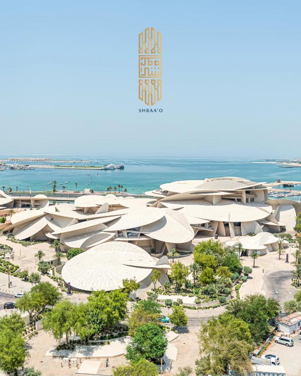 an aerial view of a beach with umbrellas at Sherao Hotel Doha - Next to National Museum of Qatar & Metro - فندق شراعوة الدوحة - بجانب متحف قطر الوطني ومحطة المترو in Doha
