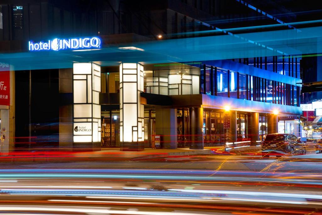 a building on a city street at night at Hotel Indigo Kaohsiung Central Park by IHG in Kaohsiung