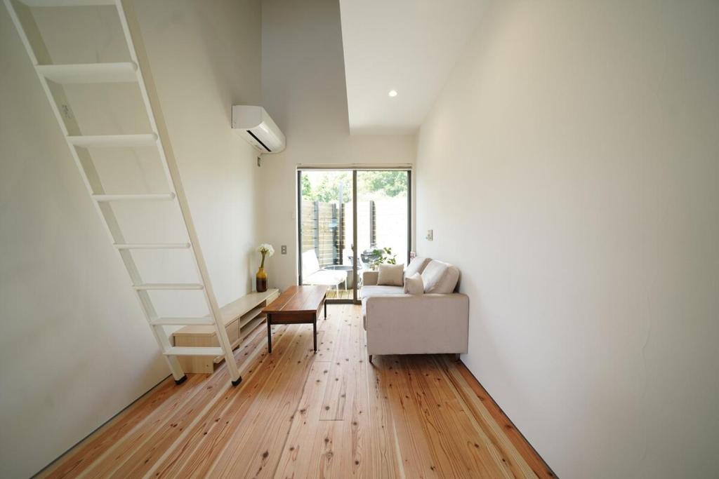 a living room with a staircase and a couch at 紀の川みんと景 in Kinokawa