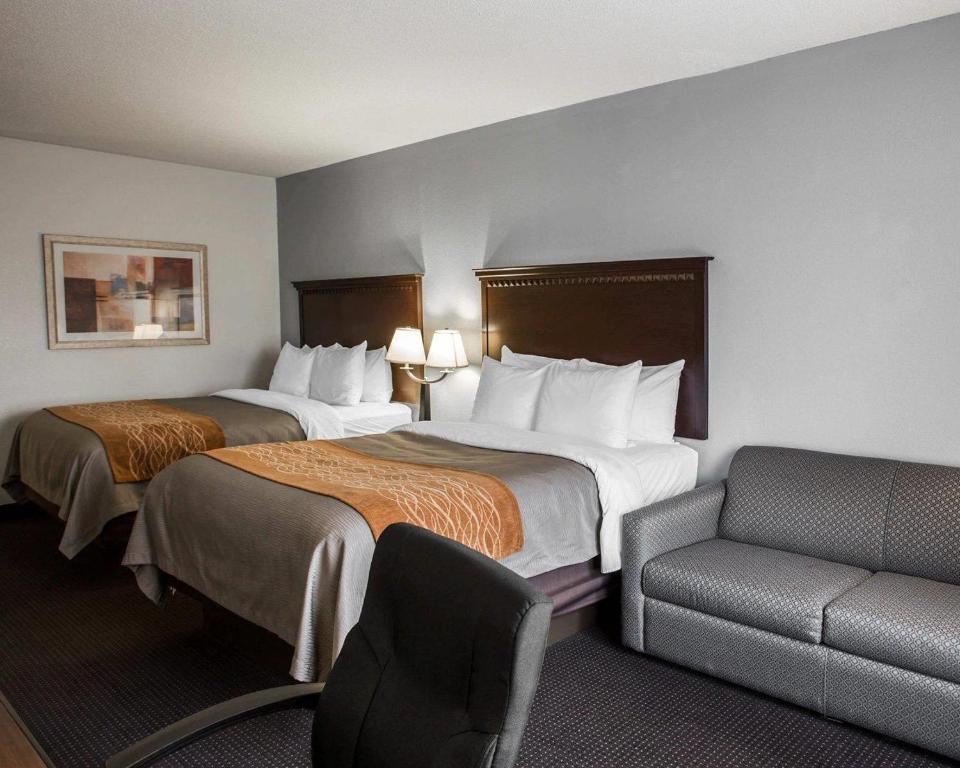 a hotel room with two beds and a chair at Comfort Inn & Suites Lumberton Central I-95 in Lumberton