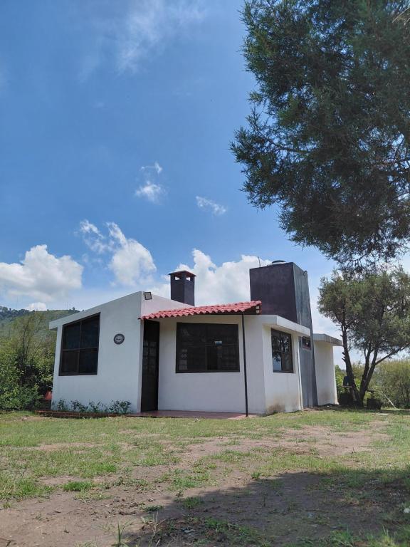 a white house with two chimneys on top of it at Finca Itaca in San Esteban Tizatlán