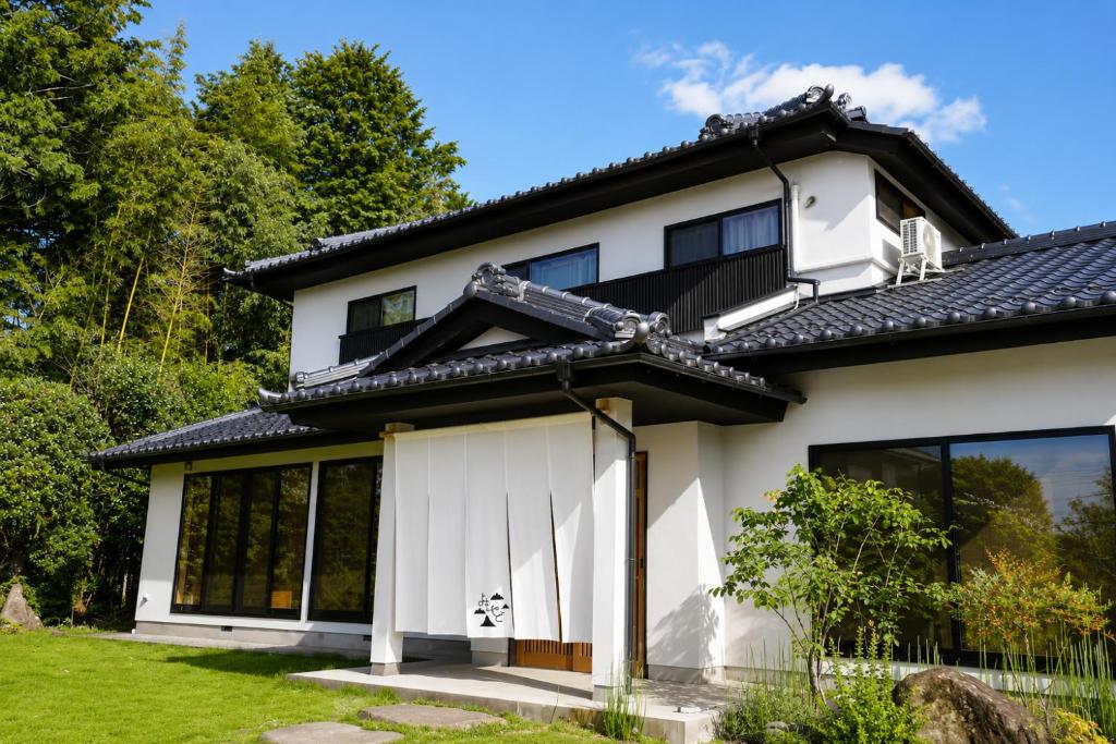 a white house with a black roof at 四方宿 in Hokuto