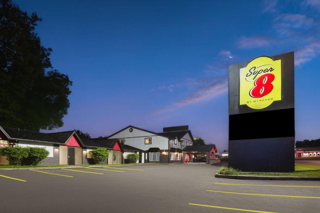 a sign in a parking lot in front of a store at Super 8 by Wyndham Gananoque - Country Squire Resort in Gananoque