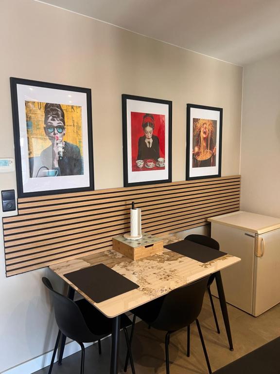 Ein Zimmer mit einem Tisch und vier Bildern an der Wand in der Unterkunft Studio CENTRAL 156 in Boussu