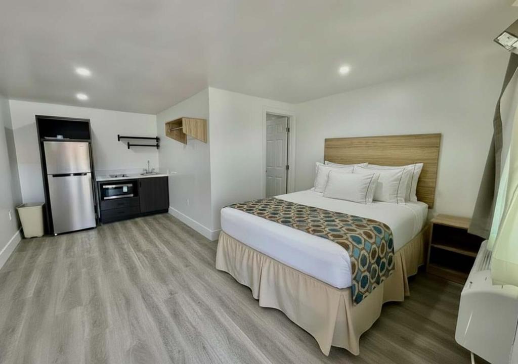 a hotel room with a large bed and a kitchen at Sun Valley Motel in Phoenix