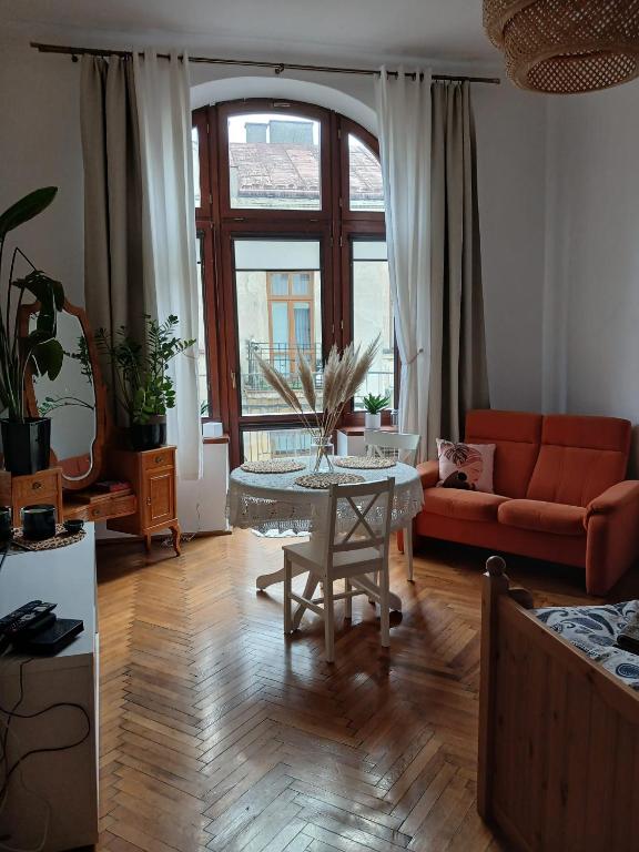 a living room with a table and a couch at Apartament Deptak Sądecki in Nowy Sącz