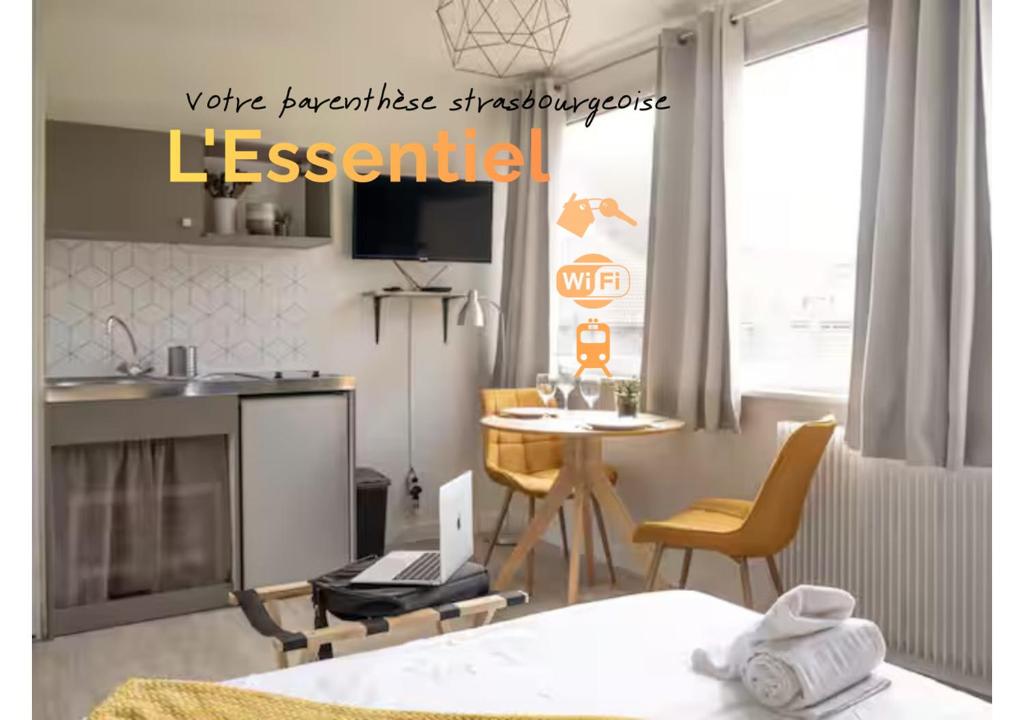 a room with a bed and a table with a laptop at L'Essentiel Confort moderne - équipements premium et tram à 5 minutes in Strasbourg