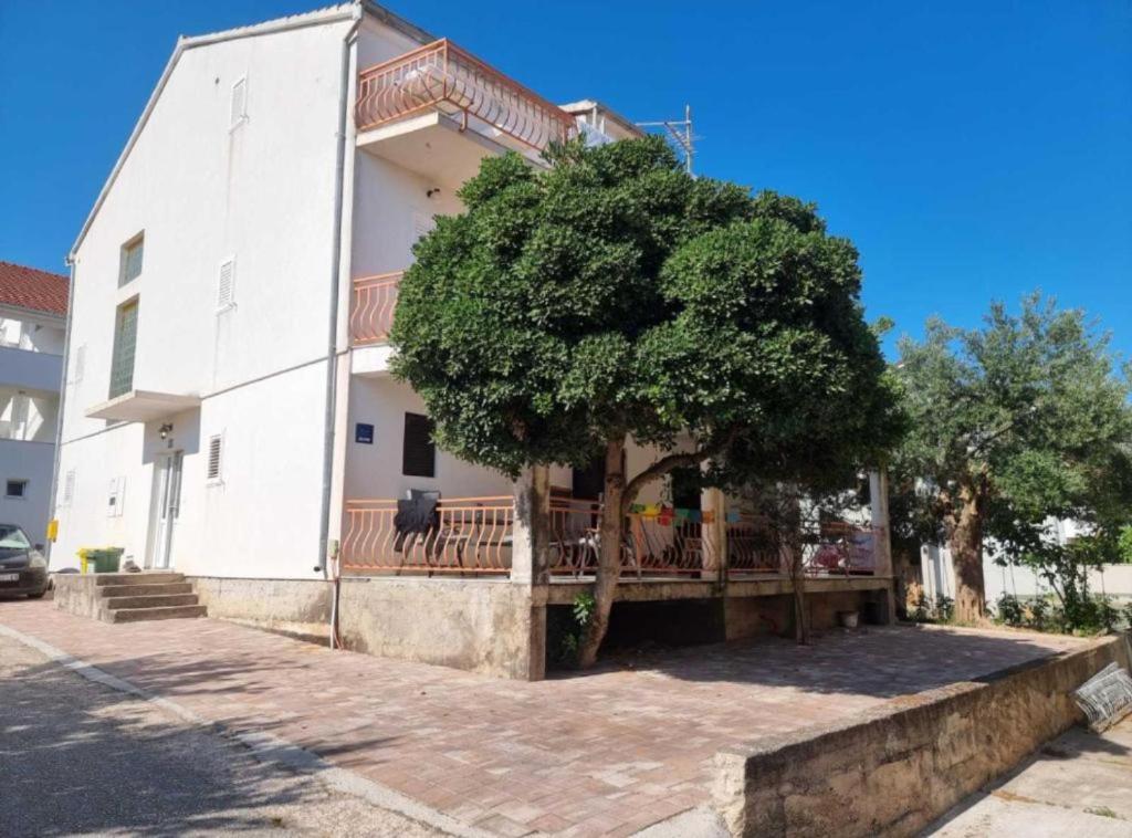 a white building with a tree in front of it at Apartments Blink in Orebić