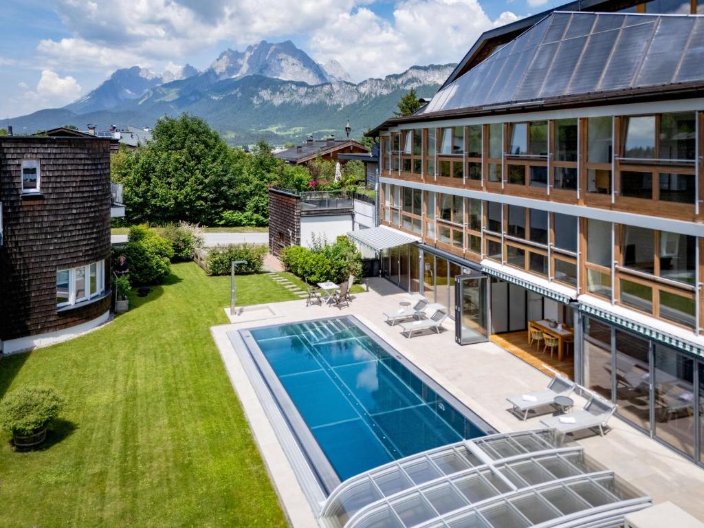 an aerial view of a house with a swimming pool and mountains at Martinshof in Sankt Johann in Tirol