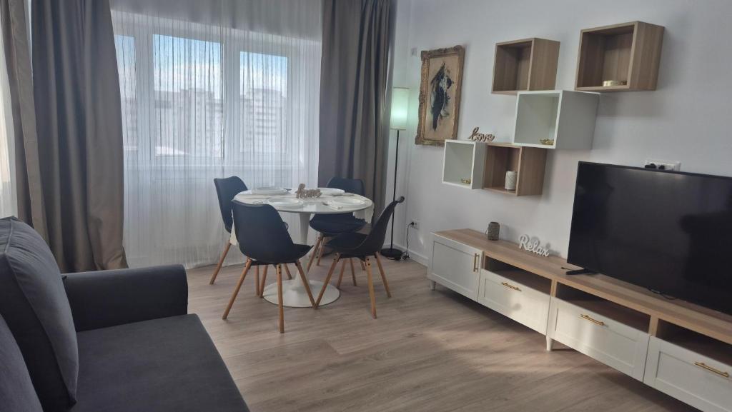 a living room with a television and a table and chairs at Unirii Residence in Bacău