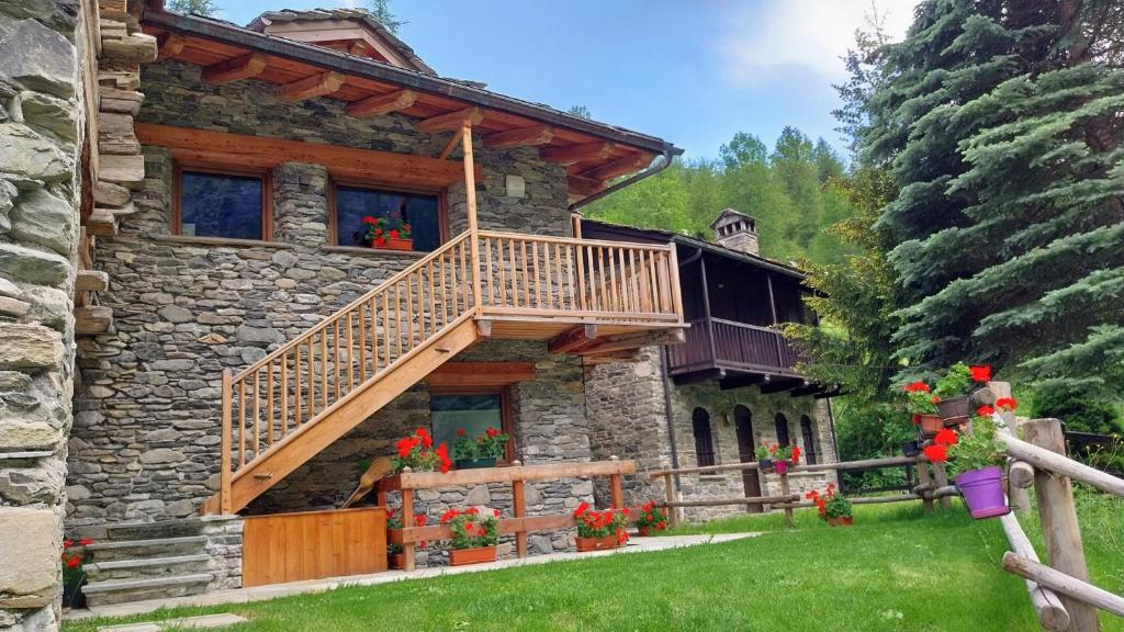 a log cabin with a balcony on the side of it at La Maison du Brenand in Rhêmes-Notre-Dame