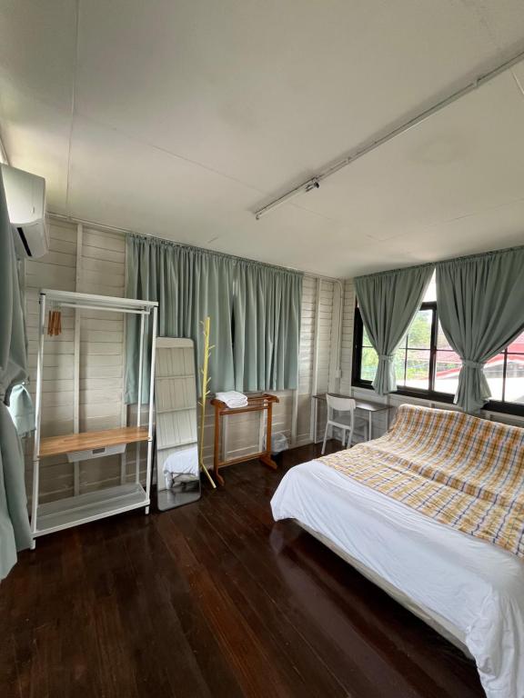 a bedroom with a bed and a large window at The Neighbors in Chanthaburi