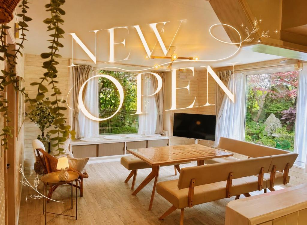 a living room with a new sign hanging from the ceiling at Private Rock Onsen Villa Orin & Zen Garden in Shiraoi