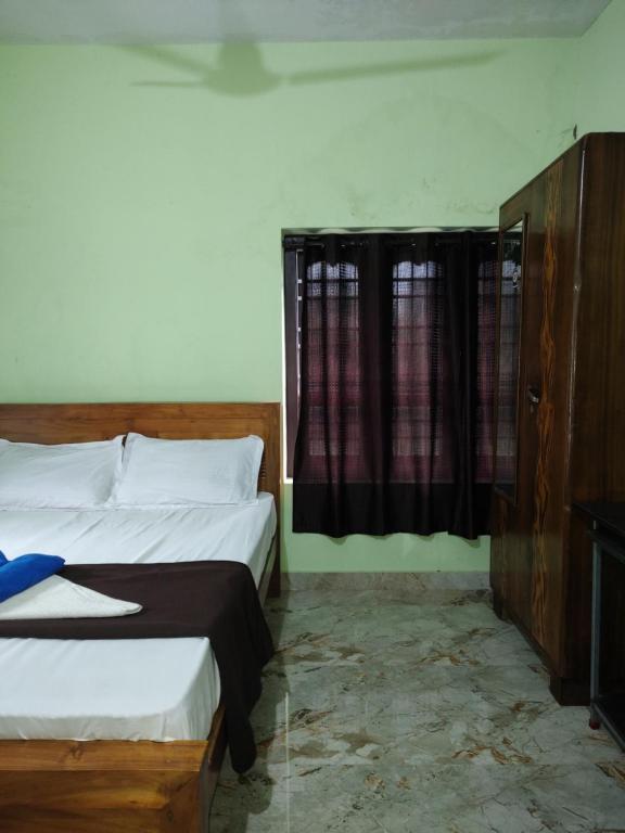 a bedroom with two beds and a window at Bridgettine Paradise 2 in Kalpetta